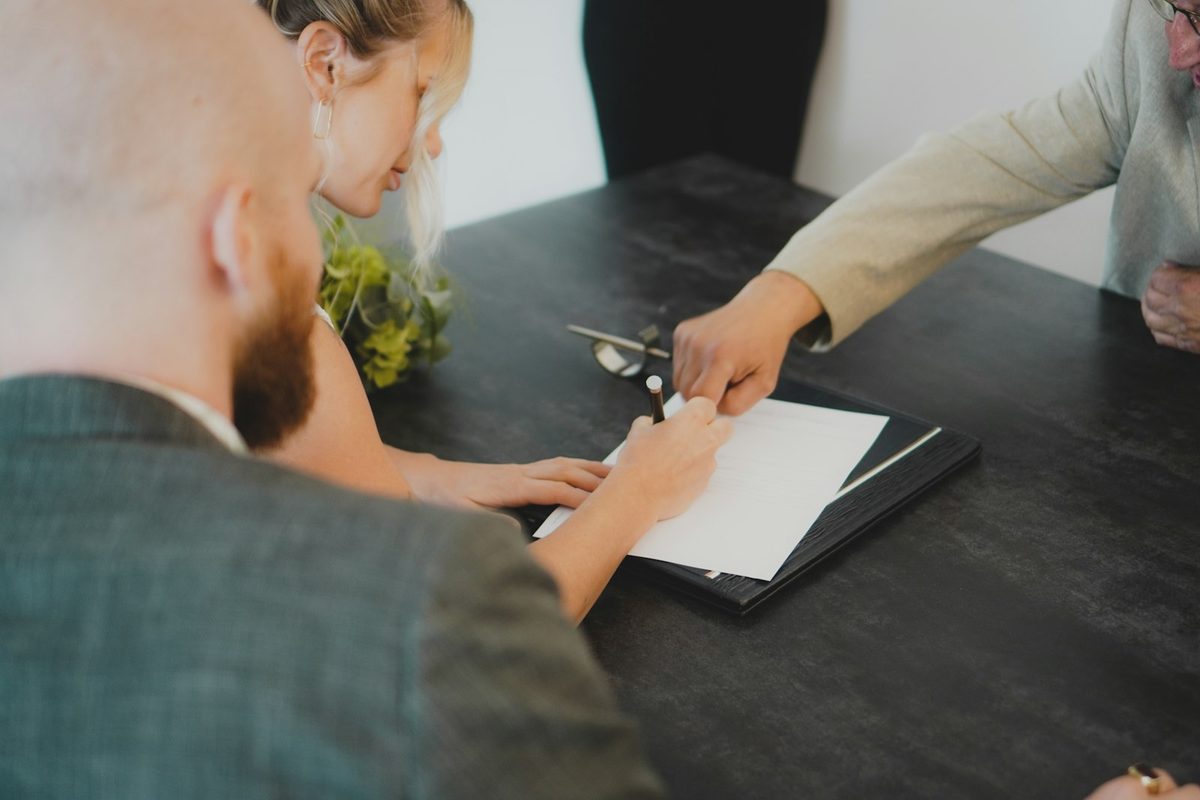 Par signerer et dokument ved et skrivebord – avtaler og gjeldsbrev kan bli tvangsgrunnlag